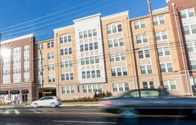 a large brick building with cars driving in front of it