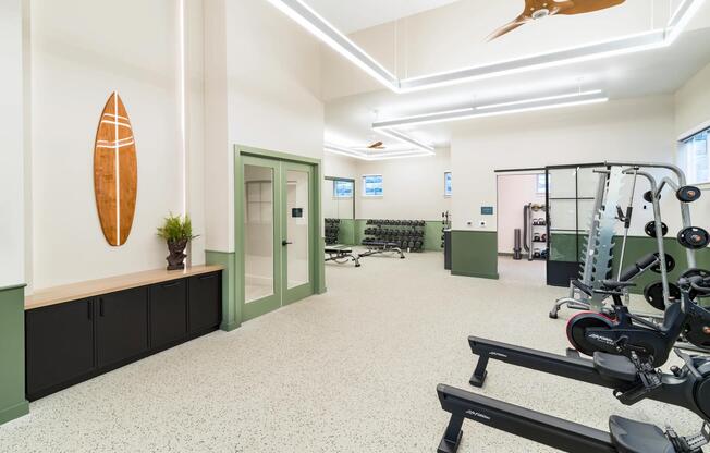 With airy ceilings and sleek coastal design, the fitness center at Modera South Shore features premium equipment—including rowers for a full-body workout.
