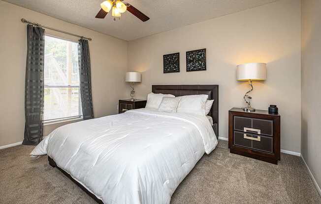 A bedroom with a large bed and a ceiling fan.