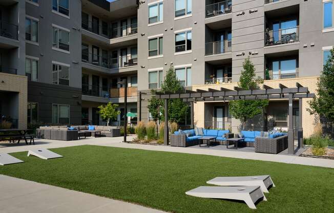 an outdoor lounge area at an apartment building with grass