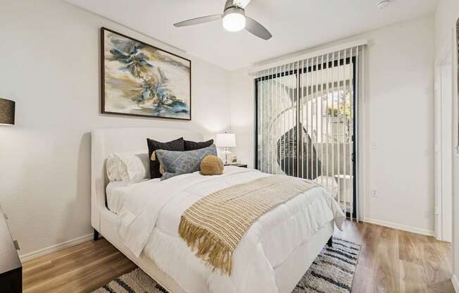 A bedroom with a large bed and a painting on the wall.