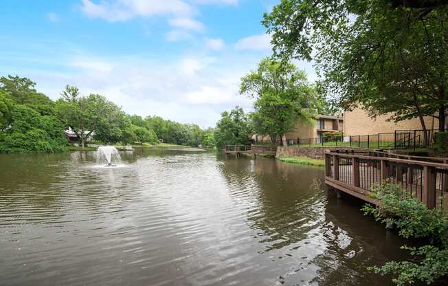 a view of a pond with a fountain in it and a building on the water