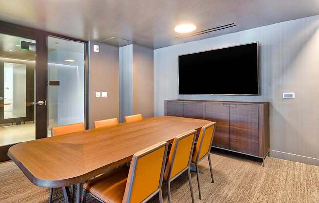 A conference room with a long table and chairs.