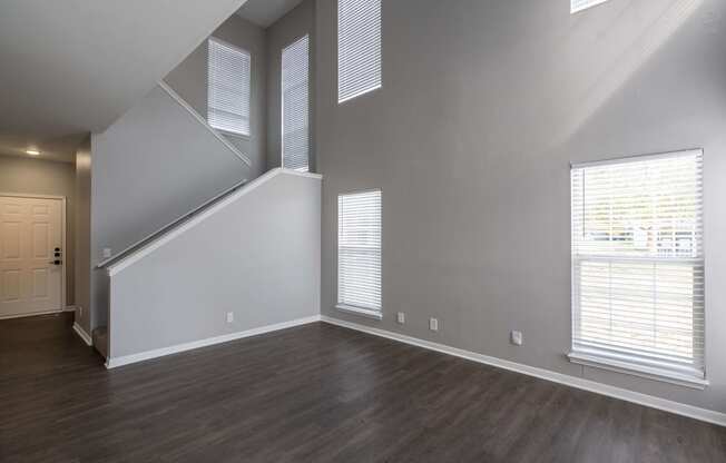 an empty living room with wood floors and white walls