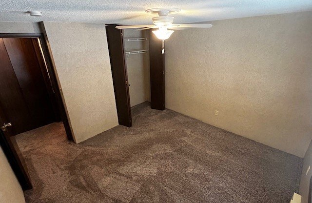 an empty room with a ceiling fan and a door