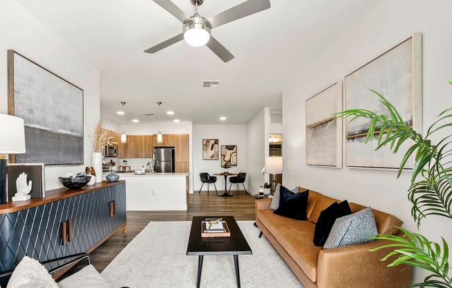 A living room with a brown couch and a ceiling fan.