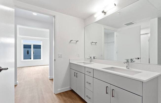 a bathroom with two sinks and a large mirror