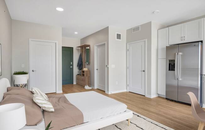 a bedroom with a bed and a refrigerator