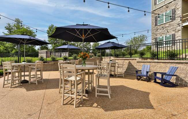 a patio with tables and chairs and umbrellas  at Aventura at Hawk Ridge, Lake St Louis, Missouri