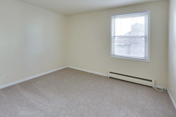 an empty room with a window and a carpet