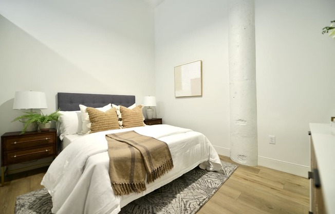 a bedroom with a white bed and a rug