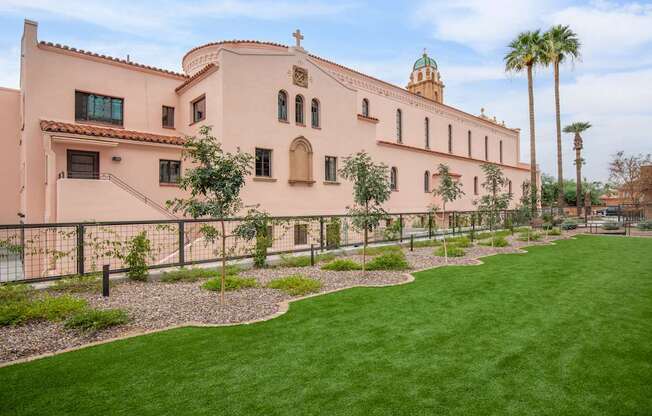 A church with a green lawn in front.