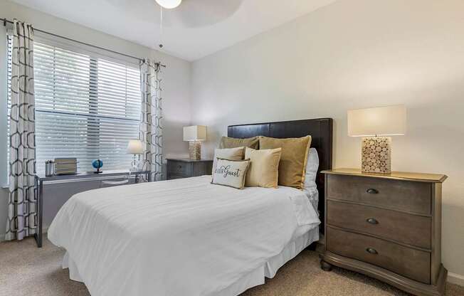 a bedroom with a large white bed and a window