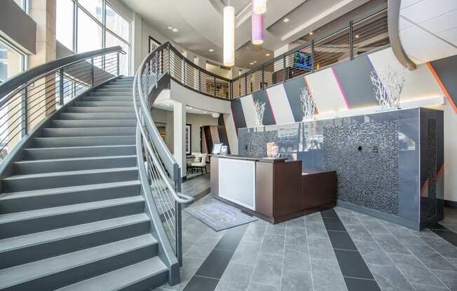 the lobby of a building with a staircase and a reception desk