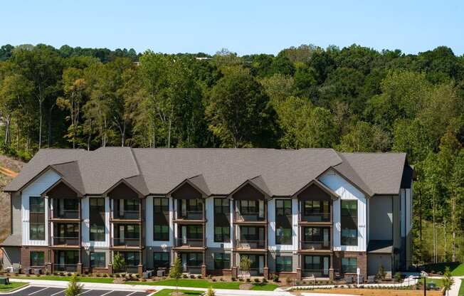 an aerial view of an apartment building with a forest in the background