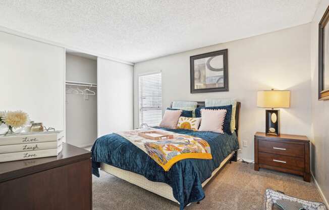 Model A2 floor plan bedroom with a bed, dresser, window Noel on The Parkway in Dallas, TX