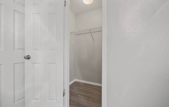 the closet in a small bedroom with a white door