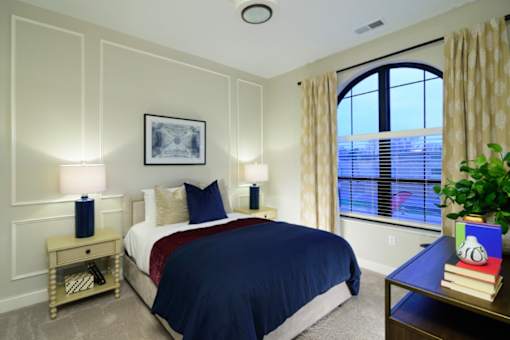 a bedroom with a large window and a bed with a blue comforter Fairfax, Grandview