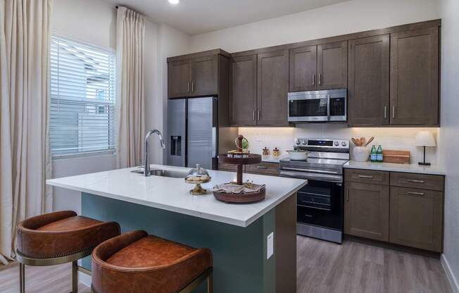A kitchen with brown cabinets and a white island with a sink.