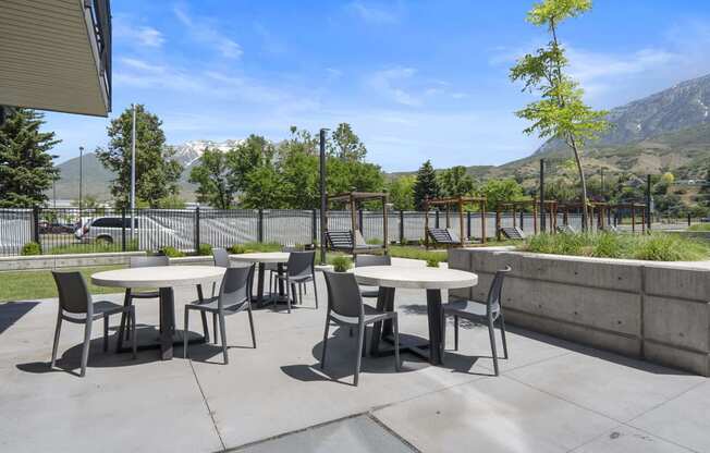 an outdoor patio with tables and chairs at The Flats at Riverwoods, Provo