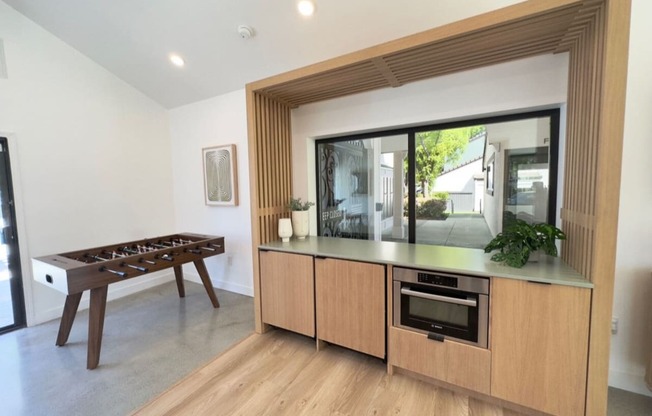 a game room with a foosball table and a large window