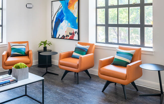 a living room with orange chairs and a table