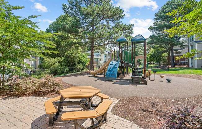 a playground with a slide and picnic tables