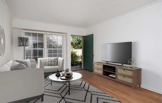 a living room with white walls and hardwood floors