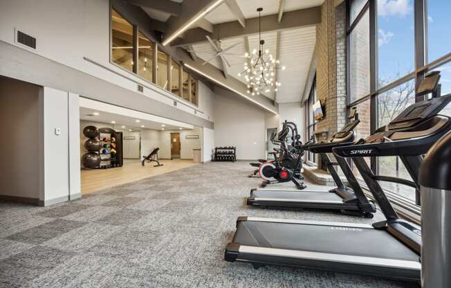 a gym with treadmills and other exercise equipment in the lobby of a building