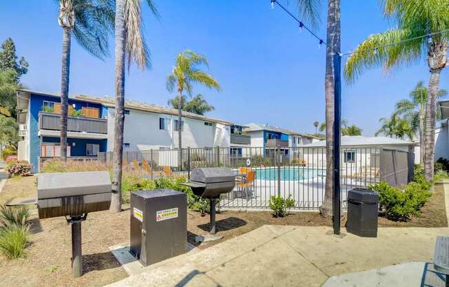 A sunny day at a residential area with palm trees and a pool.
