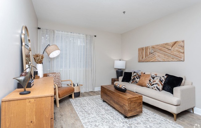 a living room with a couch and a chair and a desk