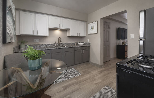 Kitchen with wood-style floors, white upper and gray lower cabinets, and stainless steel appliances at Terraces at Clearwater Beach, Clearwater, Florida