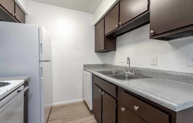 A kitchen with brown cabinets and a white refrigerator.
