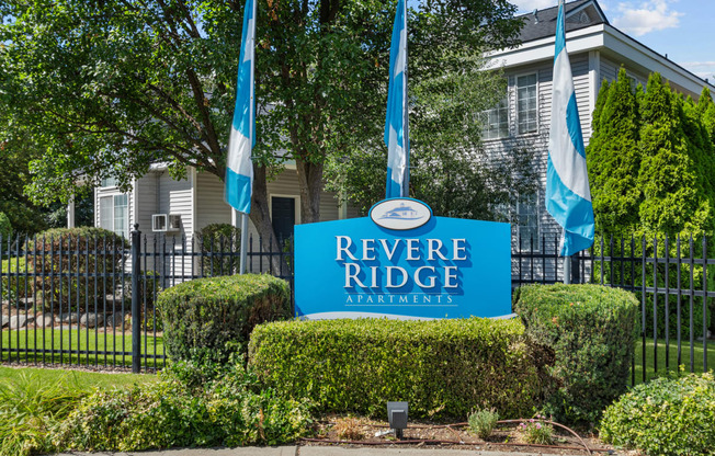 a blue reverse ridge apartments sign in front of a black fence