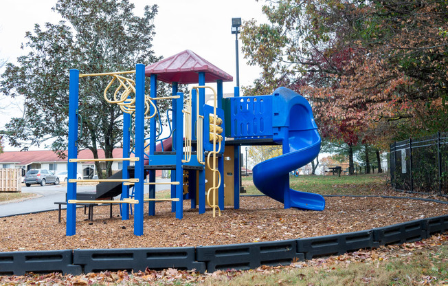 a playground at a park with a blue slide