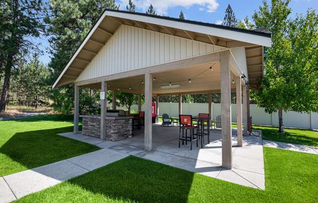 a covered patio with a table and chairs under a pavilion