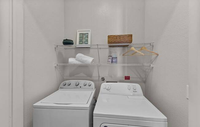 two washers and a dryer in a white laundry room