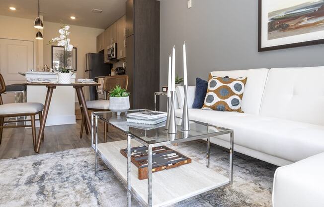 a living room with a white couch and a glass coffee table