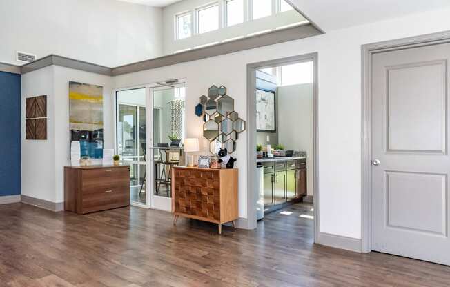 an open living room and kitchen with a wooden floor and white walls