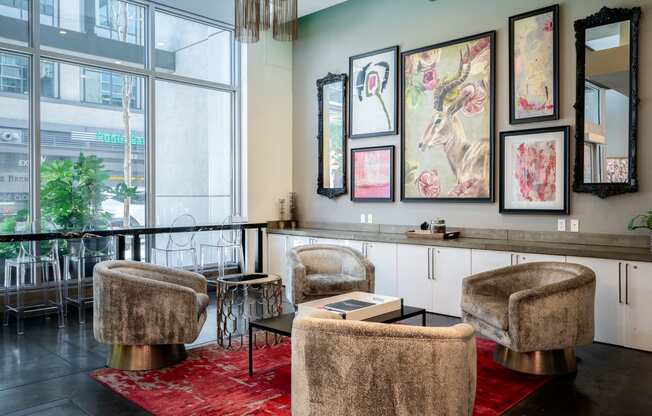 a living room with chairs and a bar and paintings on the wall