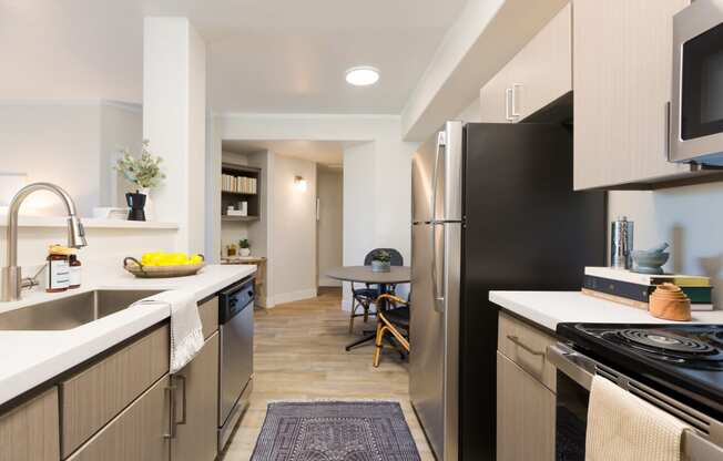 a renovated kitchen with stainless steel appliances and a dining room with a table