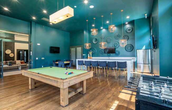 a game room with a pool table and a bar