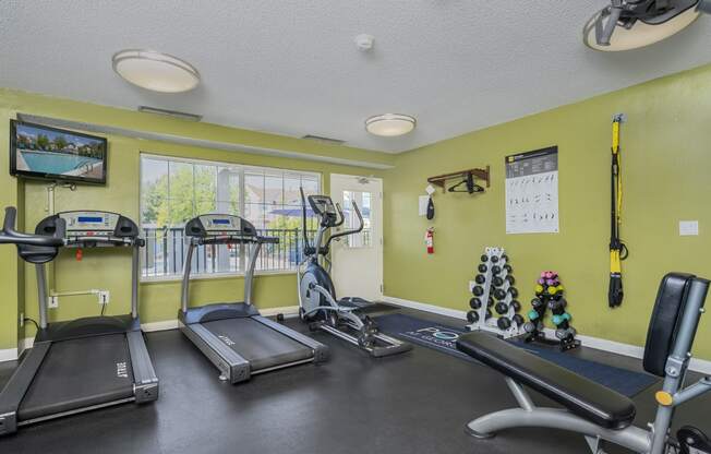 a gym with treadmills and other exercise equipment and windows