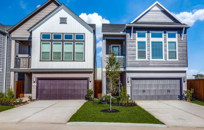 a house with two garage doors and a yard