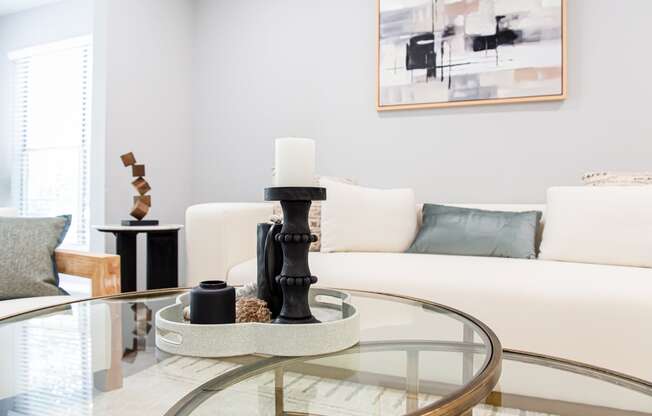 a living room with white couches and a glass coffee table at Parc at 1875, College Park