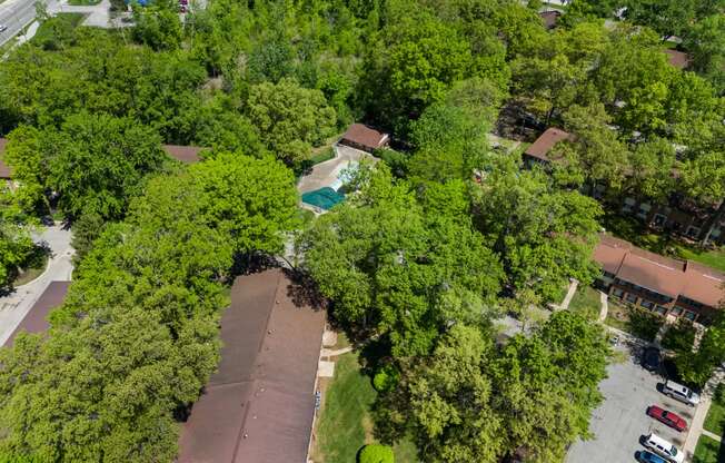 an aerial view of a neighborhood with trees and a parking lot