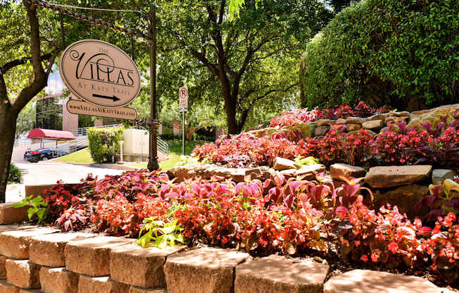 A sign that says "The Vineyards at Kate" is in front of a wall of flowers.