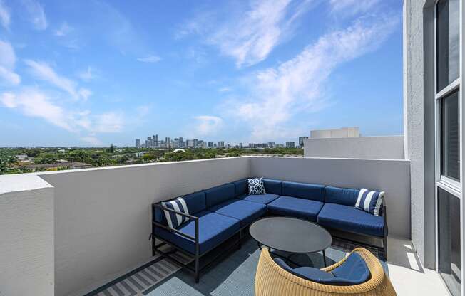 a balcony with a blue couch and a table