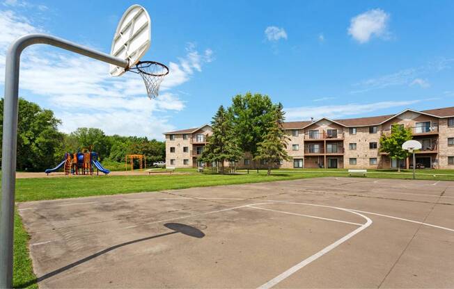 an outdoor basketball court in front of an apartment building