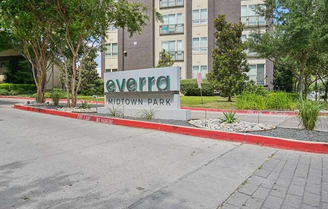 A sign that says Evergreen Midtown Park in front of a building.